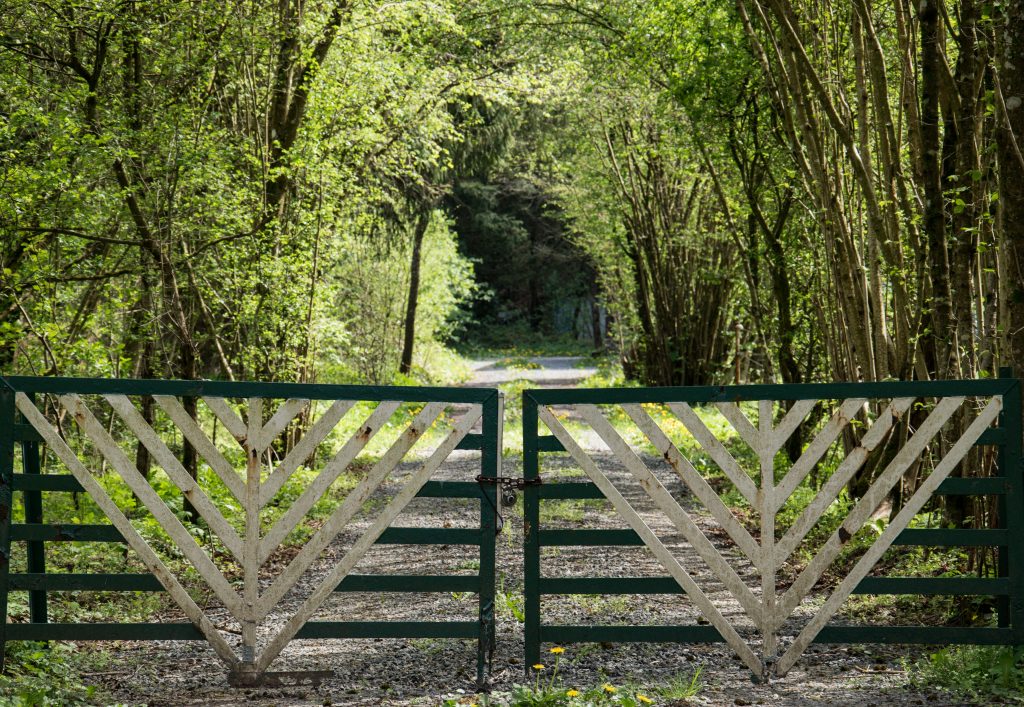 Charming wooden gate on a rural forest path in Marche-en-Famenne, Belgium.