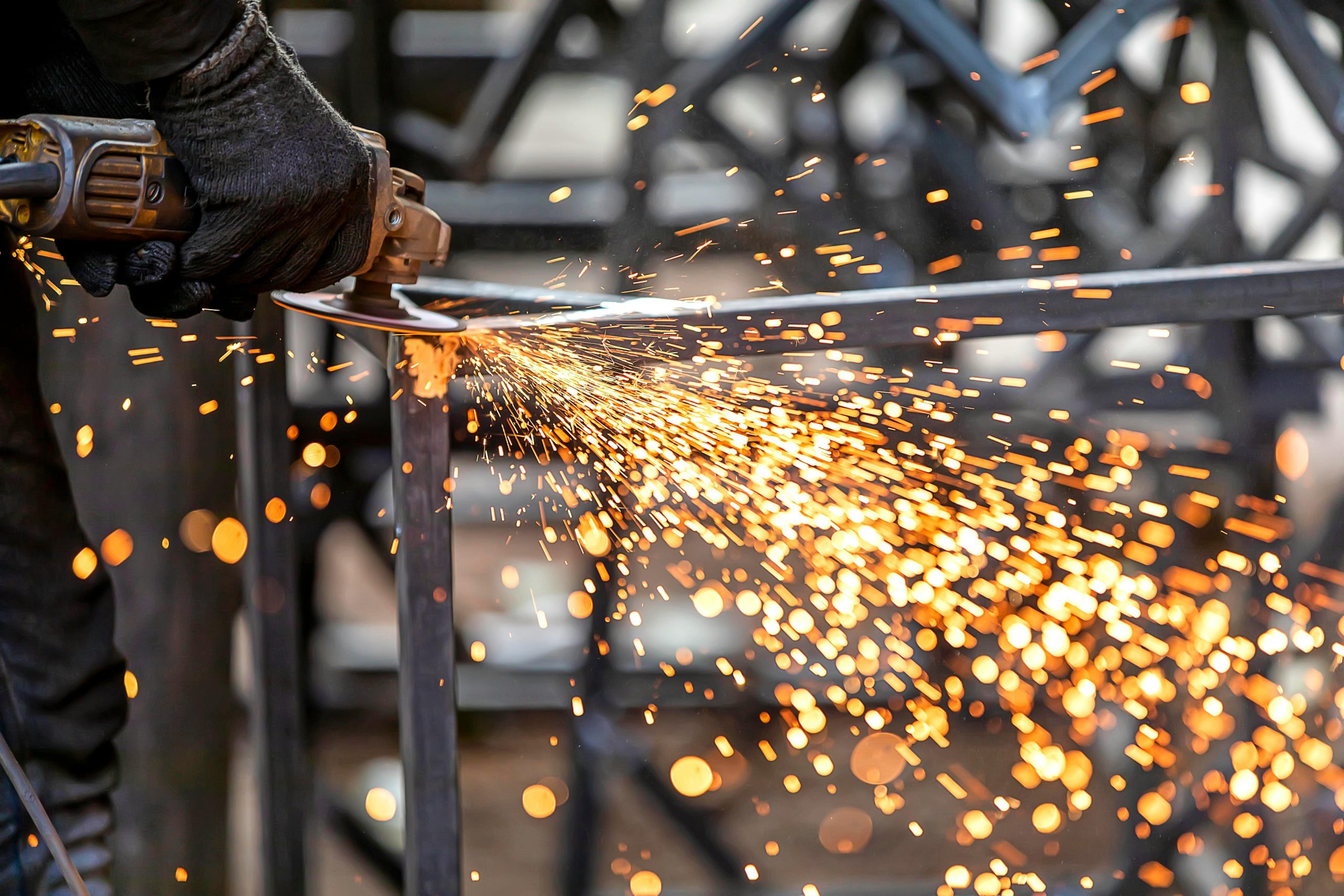 A close-up view of metal grinding with sparks flying in a workshop setting.